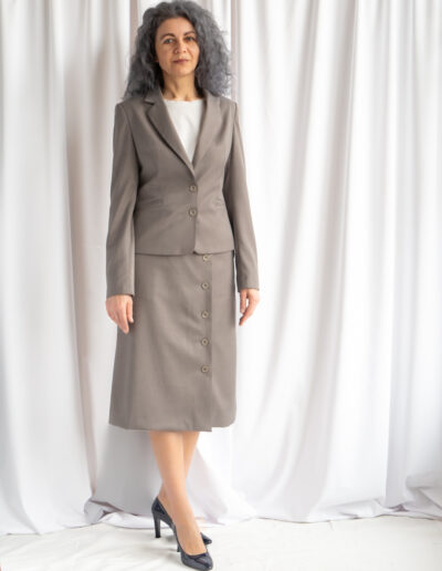 Beżowa spódnica asymetryczna z guzikami i kieszeniami.